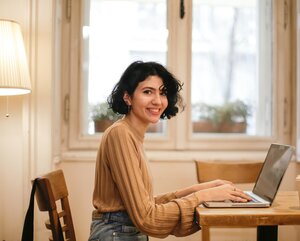 Frau blickt während eines Webinars in die Kamera