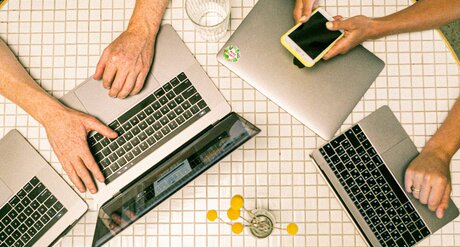 Erwerb und Ausbau digitaler Kompetenzen Tisch mit Laptops