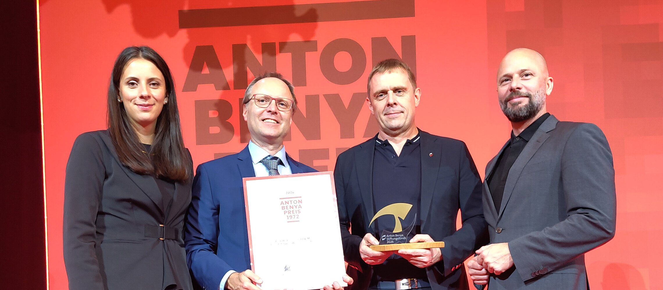 Anton Benya Preis 2020: Vier Personen stehen vor rotem Hintergrund mit „ANTON BENYA" Schriftzug.