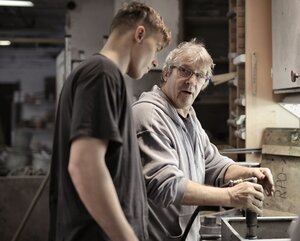 Lehrling und Ausbildner bei der Arbeit in einer Werkstatt