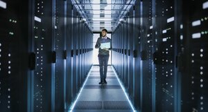 IT-Techniker arbeitet an einem Laptop in einem großen Datenzentrum 