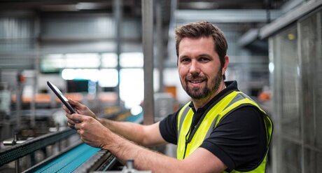 BFI-Werkmeisterschulen Mann mit gelber Warnweste im Industriebetrieb